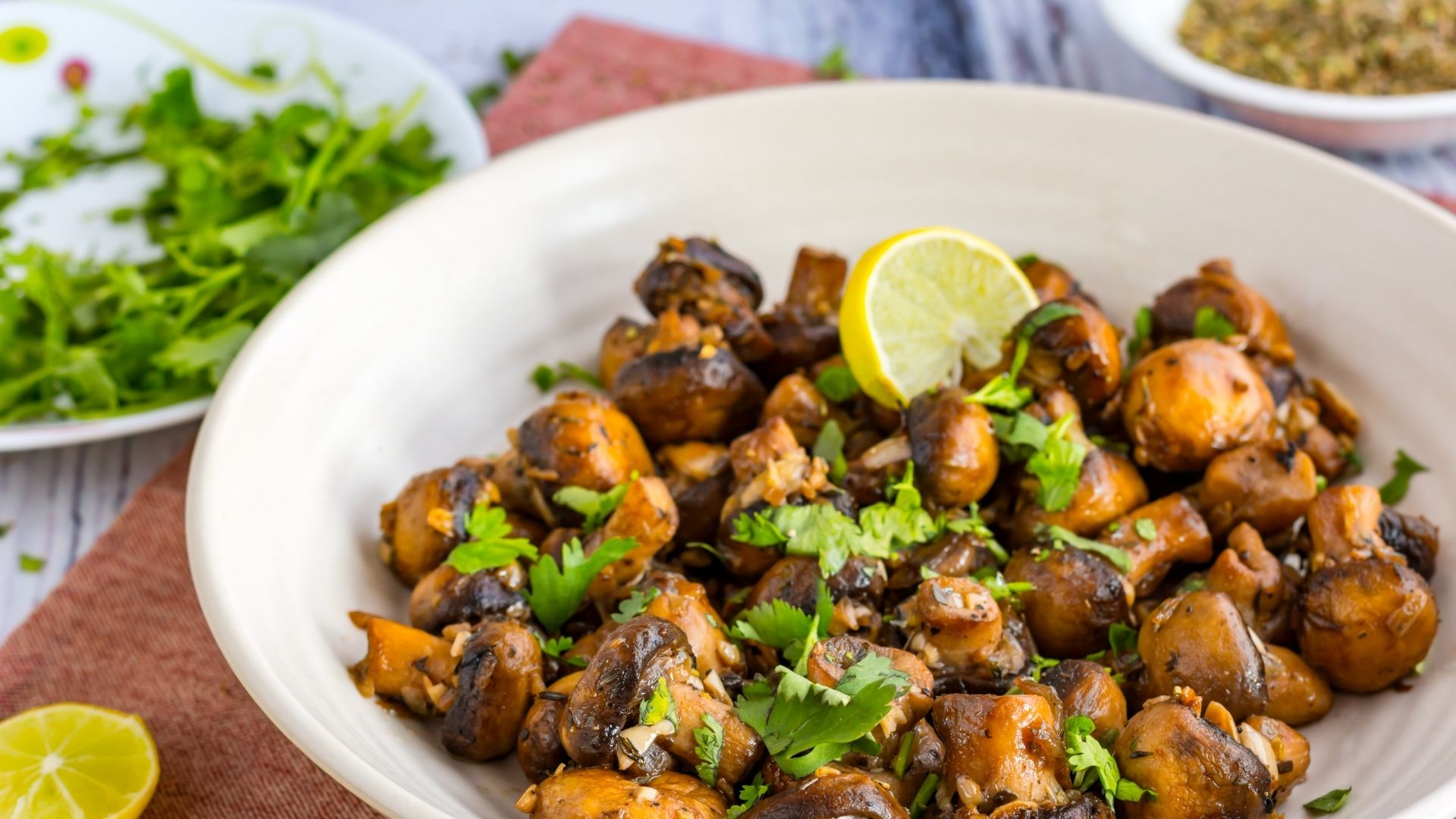 spring cooking mushrooms cooked perfectly on a nice white plate with lemon and parsely